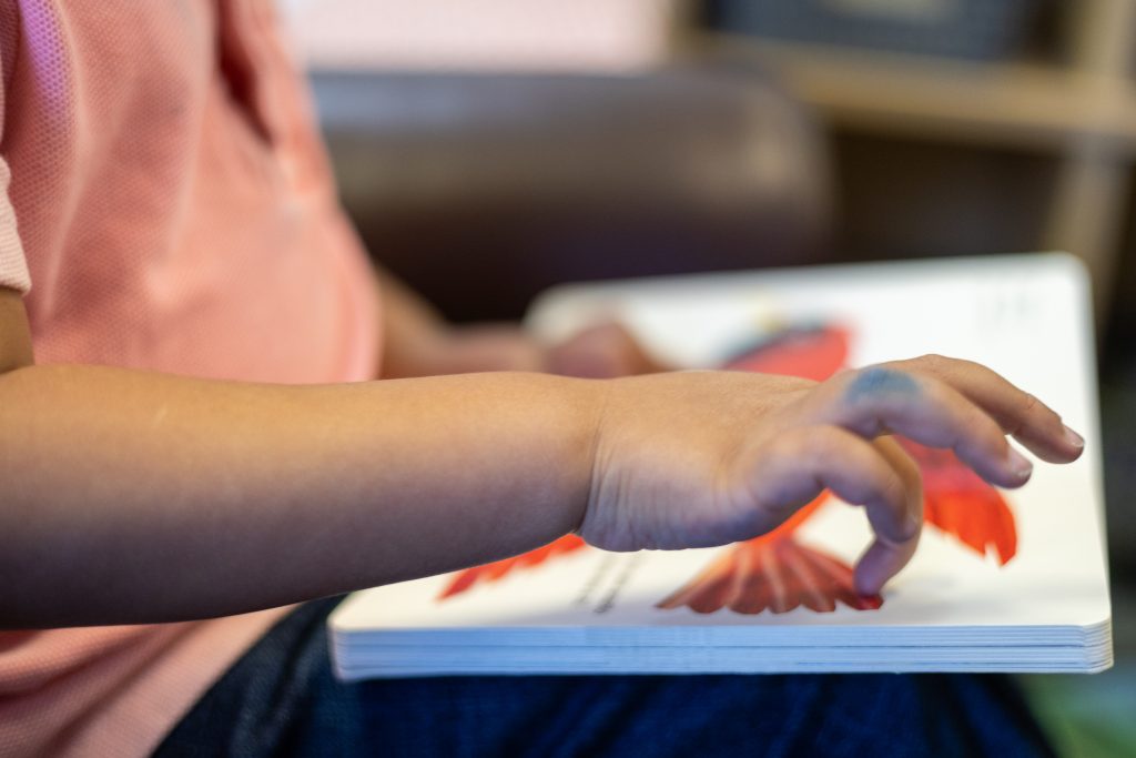 Young child finger painting during preschool craft time at a child development center near Greeley, CO
