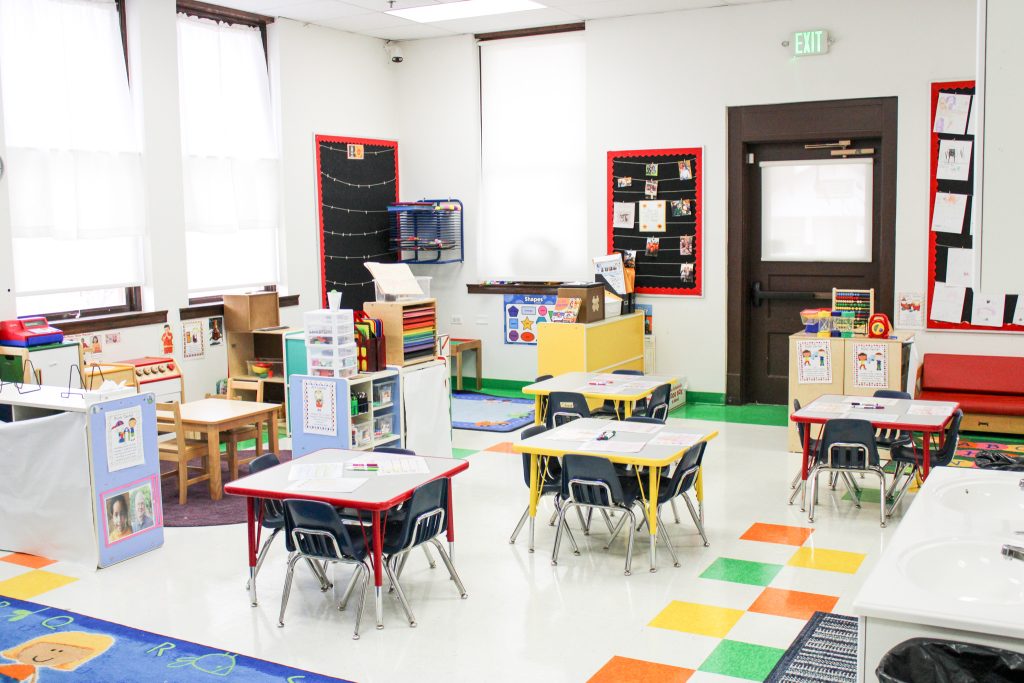 Bright and organized preschool classroom at ABC Child Development Center West in Greeley with defined activity areas, low shelves, child-sized tables, and colorful learning materials.